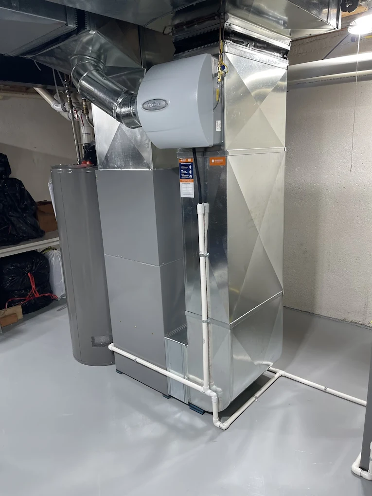 Technician measuring ductwork for furnace sizing